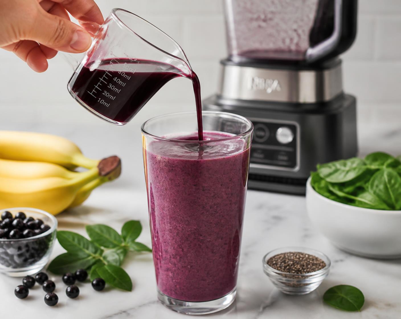 A measured 100 ml serving of Aronia juice in a glass beaker on a stone counter